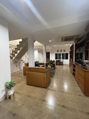 A spacious living area with a staircase, a dining area, and a kitchen. - Lovely 3-bedroom house with AC in Minburi (Krung Thep Maha Nakhon)