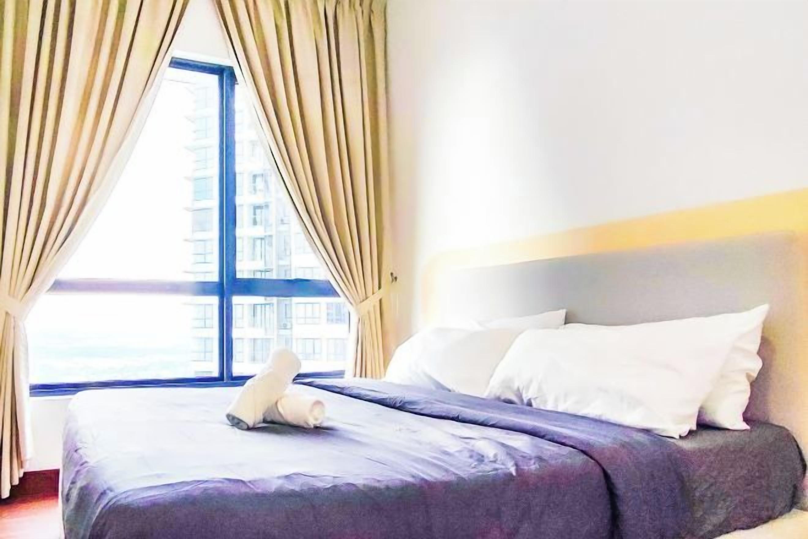 A hotel room with a bed, curtains, and a window.