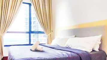 A hotel room with a bed, curtains, and a window.
