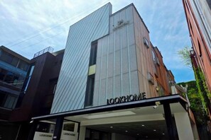 A building with a prominent 'LOOKHOME' sign, featuring a modern facade with a mix of glass and metal elements. - Look Home Guesthouse in Myeong-dong (Seoul)