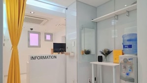 A reception area with a white desk, a water dispenser, and a sign labeled "INFORMATION". - Look Home Guesthouse in Myeong-dong (Seoul)