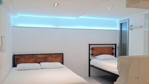 A bedroom with two beds, a wooden headboard, white bedding, and a ceiling with recessed lighting. - Look Home Guesthouse in Myeong-dong (Seoul)