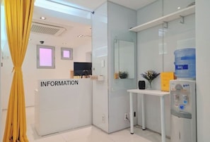 A reception area with a white desk, a water dispenser, and a sign labeled "INFORMATION". - Look Home Guesthouse in Myeong-dong (Seoul)