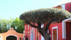 A red building with a tree in front, a staircase, and a clear sky. - Villa '23 Maria Callas' with Private Terrace, Wi-Fi and Air Conditioning (Ramatuelle)