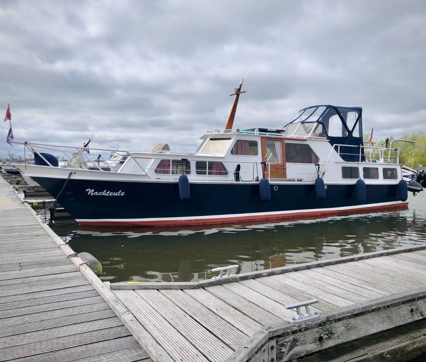 A boat named 'Nachteule' docked at a wooden pier.