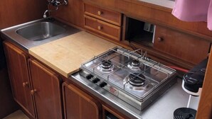 Une cuisine de taille réduite, équipée d’un évier, d’une cuisinière et de placards.
