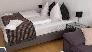 A modern hotel room with a bed, bedside tables, a sofa, and a dining table. - Marsktures motel (Højer)