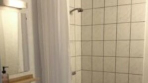A bathroom with a sink, mirror, and shower area. - Marsktures motel (Højer)