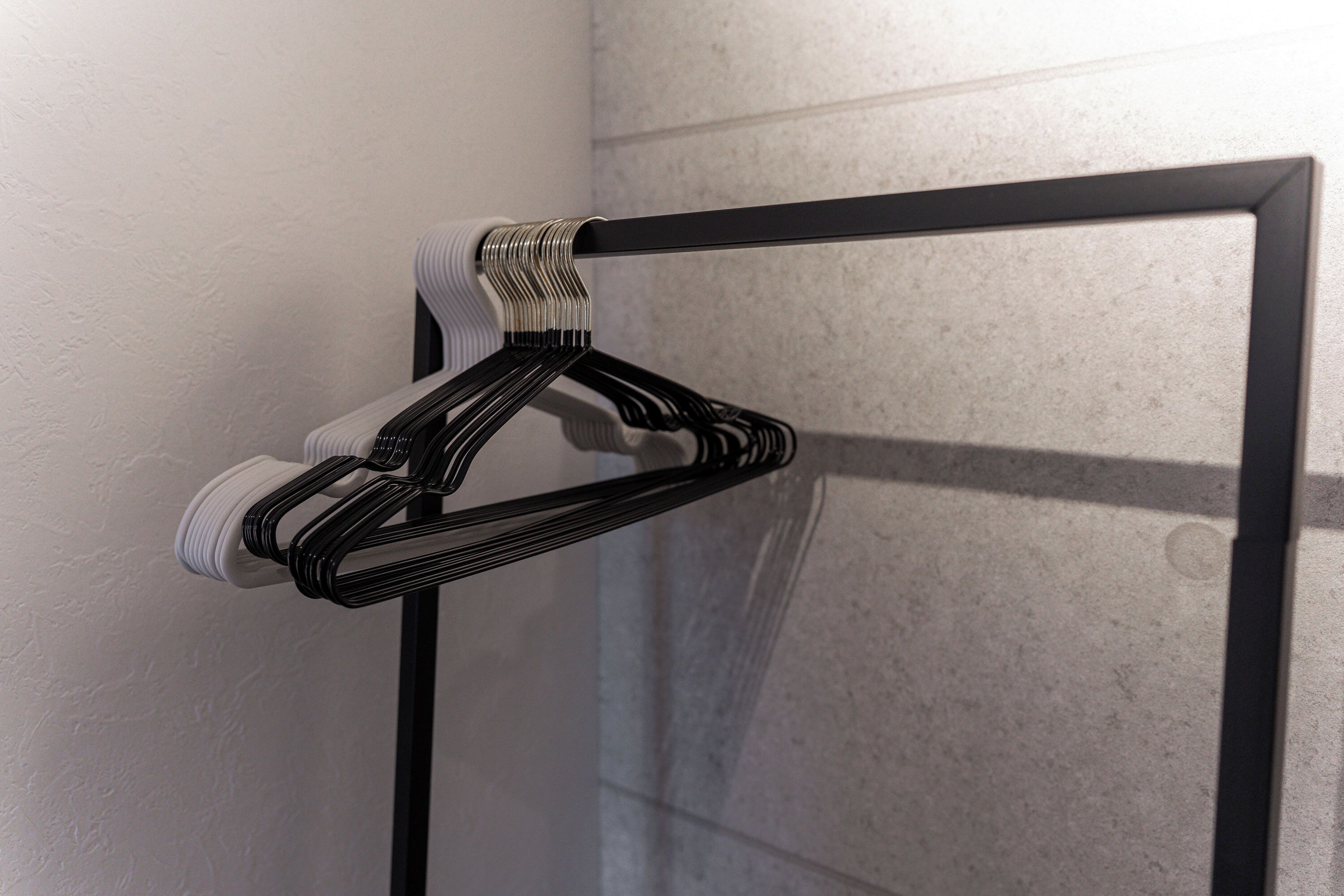 A black metal frame with a white towel hanging on it.