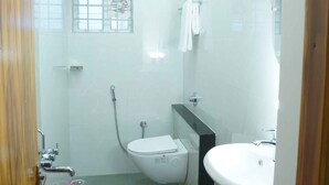 Un baño pequeño y bien iluminado, con inodoro, lavabo y ducha.