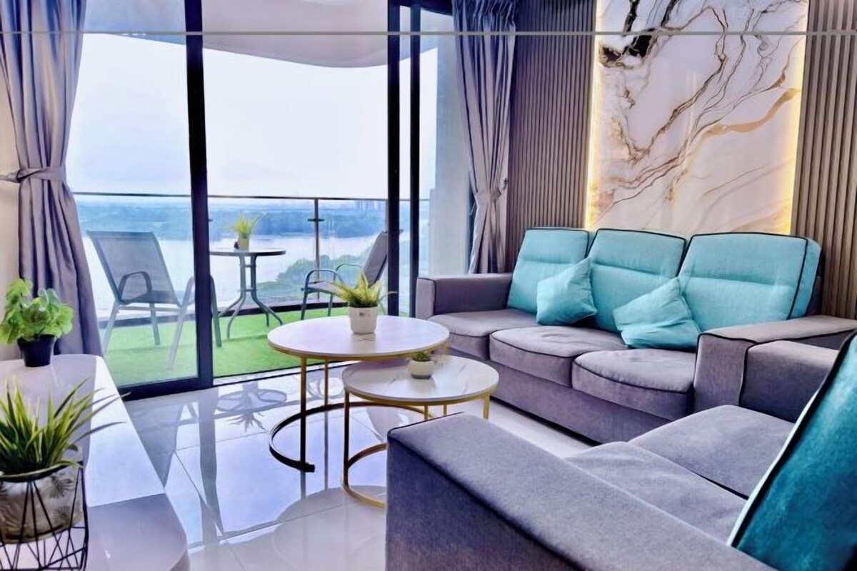 A modern living room with a sofa, a round coffee table, and a view of the outdoors.
