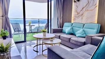 A modern living room with a sofa, a round coffee table, and a view of the outdoors.