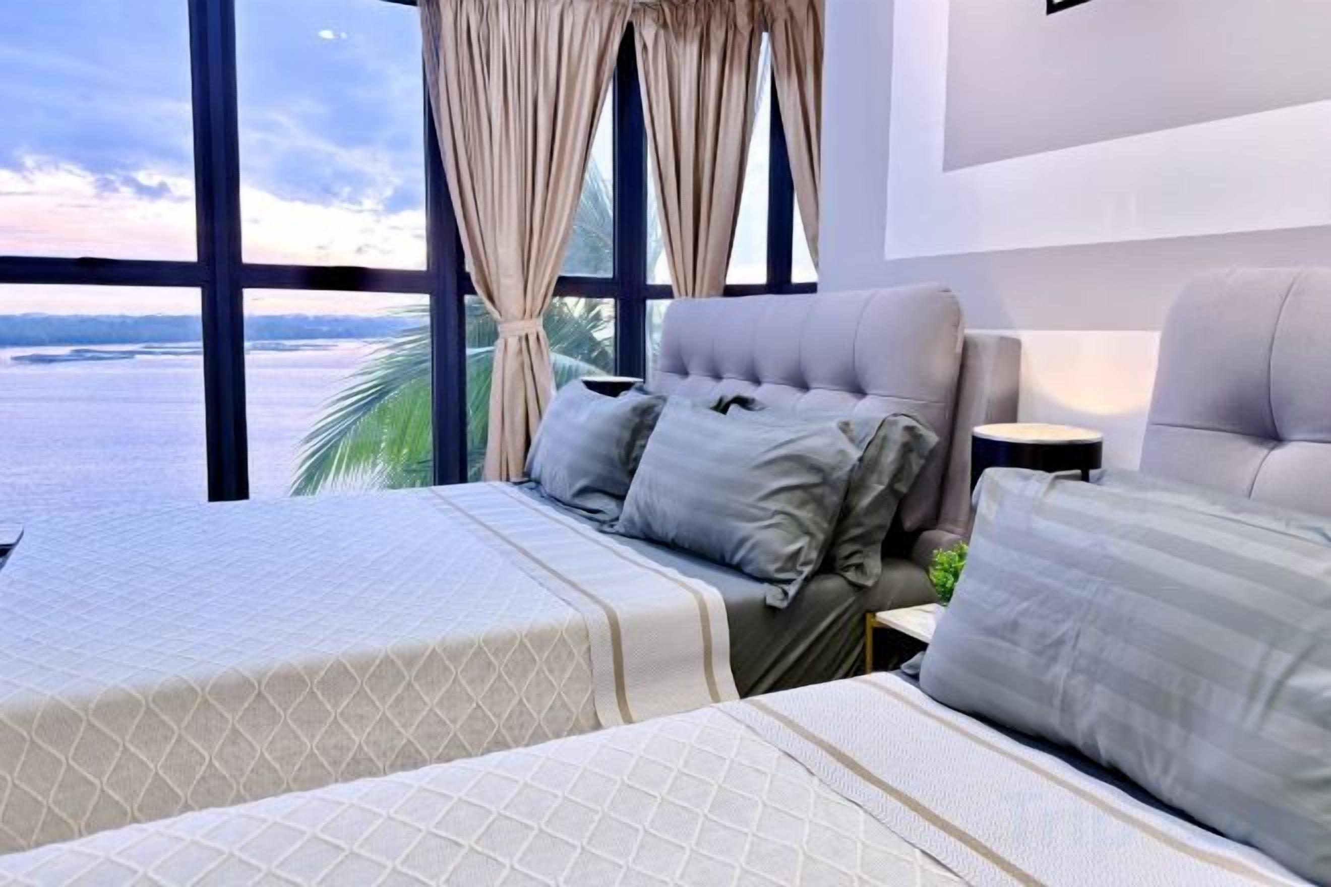 Quarto de hotel com cama, sofá e vista para o mar.