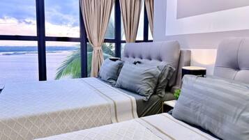 Quarto de hotel com cama, sofá e vista para o mar.
