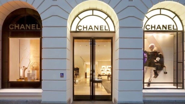 Een Chanel winkel met drie gewelfde entrees, elk met etalagepoppen in het raam.