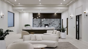 Ein modernes, helles Wohnzimmer mit einem weißen Sofa, einem Couchtisch und einer Rezeption.