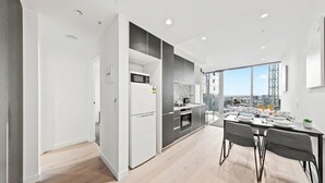 Eine moderne Küche mit Essbereich, großen Fenstern und Blick auf die Stadt.