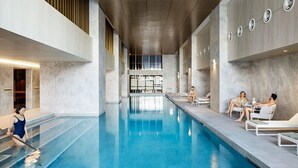 Ein überdachter Schwimmbereich mit freiem Blick auf das Becken, einschließlich Sitzgelegenheiten am Beckenrand und der Beckenkante.