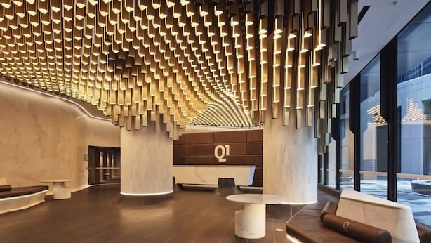 A modern lobby with a unique ceiling design, a reception desk, and seating areas. - Lovely 3BR Apt With Panoramic Views, Free Parking (Melbourne)