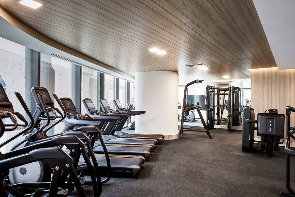 Et fitnesscenter med løbebånd, styrkemaskiner og træningsudstyr.