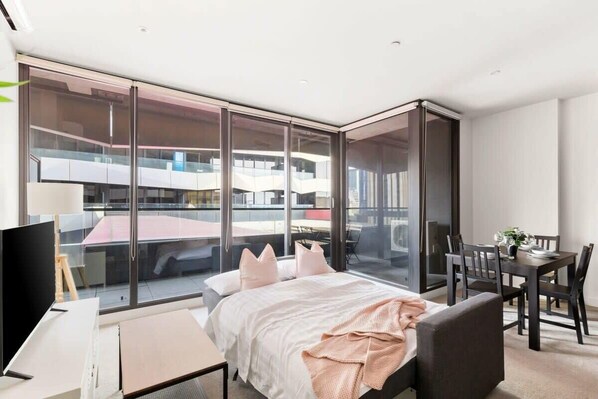 Een moderne hotelkamer met een groot bed, een bureau en een zithoek.