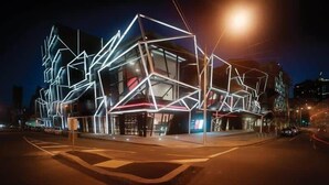 A modern building with geometric light installations at night.