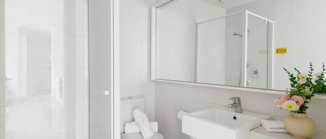 Un baño moderno con inodoro, lavabo y ducha.