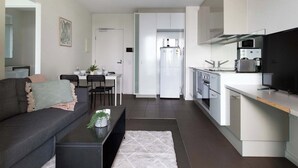 A modern kitchen with white cabinets, a built-in oven, and a microwave. - Southern Cross Gem: Modern Home With harbour Views (Melbourne)