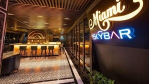 A bar area with a neon sign reading 'Miami SkyBAR' and a bar counter with stools. - MADELISE HOTEL&APARTMENT (Haiphong)