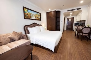 A bedroom with a bed, a sofa, a desk, and a chair. - MADELISE HOTEL&APARTMENT (Haiphong)