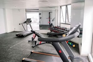 A gym with treadmills, a bench, and dumbbells. - MADELISE HOTEL&APARTMENT (Haiphong)
