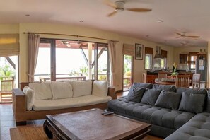 Ein Wohnzimmer mit einer Couch, einem Couchtisch und einem Essbereich mit Tisch und Stühlen.