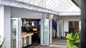 A modern hotel lobby with a glass partition, a reception desk, and a sign indicating a restaurant. - High Floor Suasana Suites 5 in JB City With Wifi (Johor Bahru)