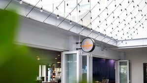 A modern interior with a glass door entrance, a ceiling with hanging lights, and a sign for 'Samantha's Bites Cafe'. - High Floor Suasana Suites 5 in JB City With Wifi (Johor Bahru)