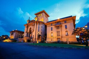A large, historic building with classical architecture, featuring a prominent tower and arched windows.