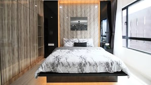 Un dormitorio moderno con una cama, un cuadro de paisaje urbano en la pared y un ventanal grande.