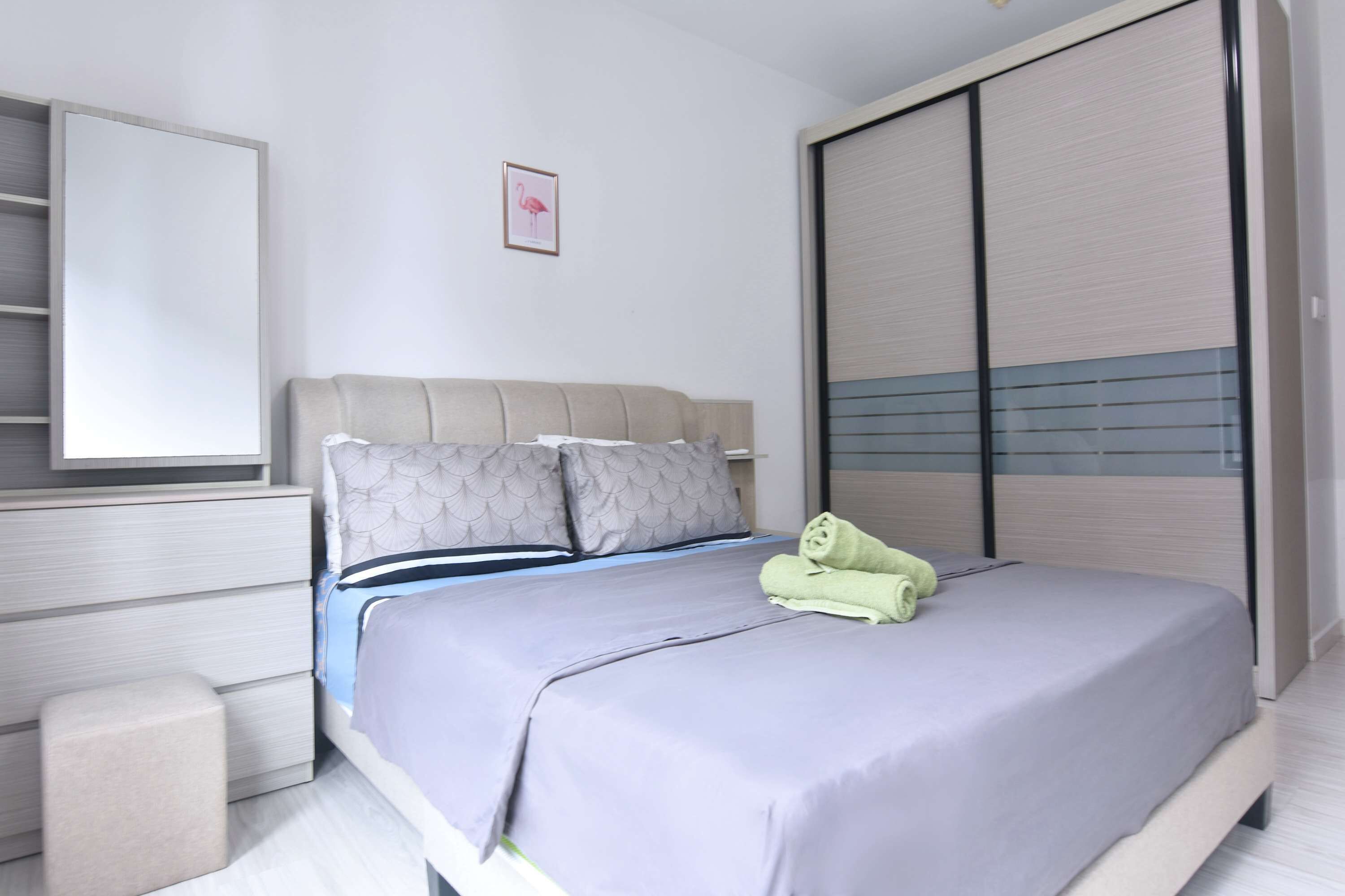 Ein modernes Schlafzimmer mit Bett, Nachttisch, Kleiderschrank und einem gerahmten Bild an der Wand.