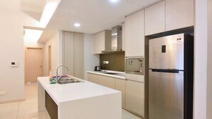 A modern kitchen with a central island, stainless steel appliances, and a minimalist design. - Pet Friendly, 3BR Apt KL, Bathtub & Parking (Kuala Lumpur)