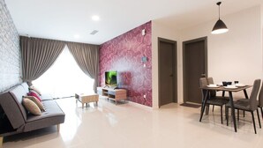 Una sala de estar moderna con sofá, televisión y comedor.