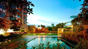 A swimming pool surrounded by lush greenery and modern buildings. - A Stylish High Floor 3BR Apt at Bukit Bintang (Kuala Lumpur)