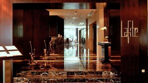 A modern lobby with a marble reception desk, a water feature, and a 'Latte' sign on the wall. - A Spacious 4BR Home Nearby Kiara Hill, Mont Kiara, Pavilion Damansara Heights (Kuala Lumpur)