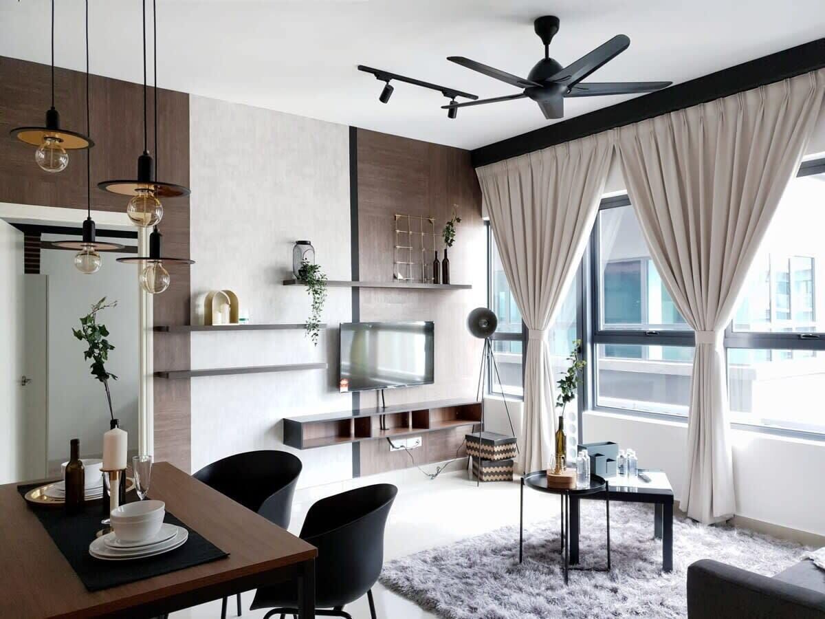 A modern living room with a dining area, a TV mounted on the wall, and a ceiling fan.