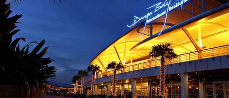 A large, modern building with a curved roof and a sign that reads "Danya Bay International Restaurants."