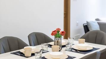 A dining table set with plates, cups, and a vase of flowers.