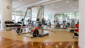 A gym with weightlifting equipment, cardio machines, and a mirror wall. - Central 2BR Apt 5 Mins Klcc Twin Towers, Bathtub (Kuala Lumpur)