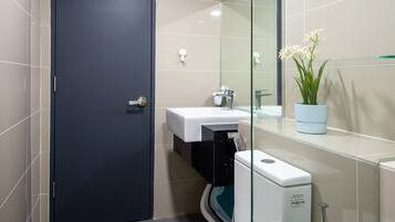 Un baño moderno con inodoro, lavabo y cabina de ducha de vidrio.