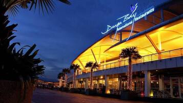 A multi-story building with a curved roof and a sign that reads "Dora Bay International Restaurant".