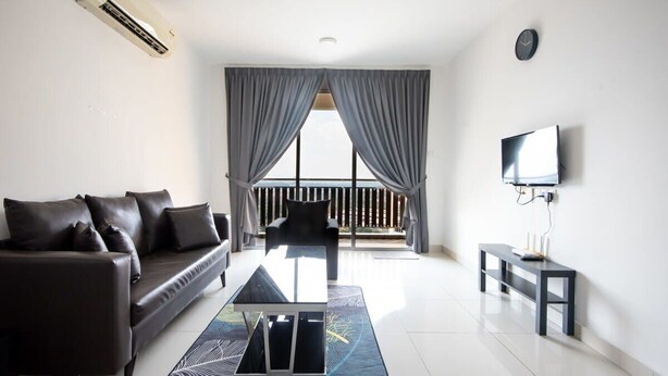 A modern living room with a sofa, a coffee table, a TV, and a balcony with curtains. - Comfy 3BR Apt @ KSL Daya Near Ikea Tebrau, Parking (Johor Bahru)