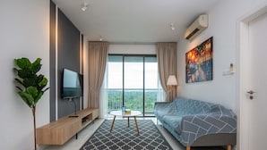Una sala de estar moderna con televisor, sofá, mesa de centro y una planta.