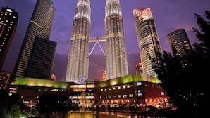 The Petronas Twin Towers with surrounding high-rise buildings, a bridge, and a hotel in the foreground. - A Stylish 2BR Home, 5min Walk to Klcc (Kuala Lumpur)